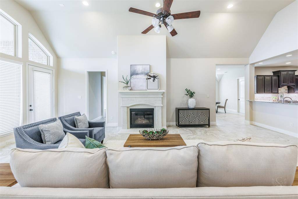 This magnificent family room provides a lovely gathering place for your family and friends! Featuring a high ceiling, fireplace and mantel and wall of windows bringing in lots of natural light! There's plenty of room for all the furniture you need for your family and guests.