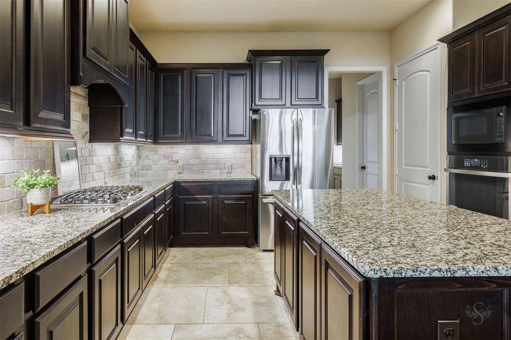 The spacious kitchen features stunning granite countertops and a matching granite-topped island, making it both practical and stylish. With a gas cooktop, plenty of cabinetry, and a convenient butler's pantry, it's a chef's dream for preparing meals and entertaining.