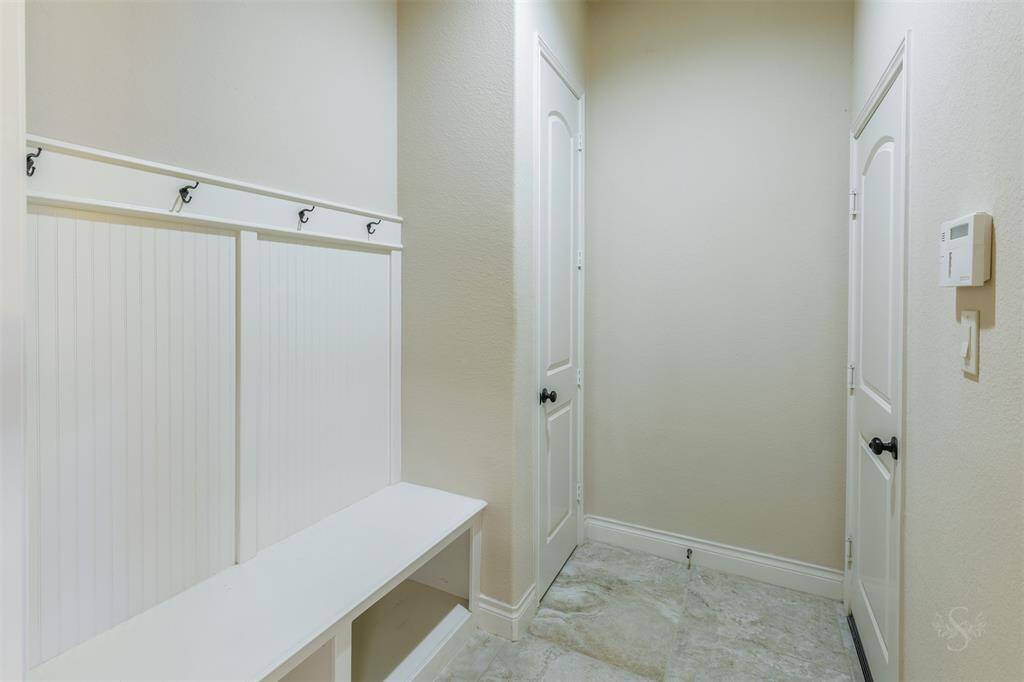 This functional mudroom area provides a convenient spot for hanging backpacks and jackets, keeping everything organized. It also offers ample storage for shoes, making it easy to stay tidy when entering from the garage.
