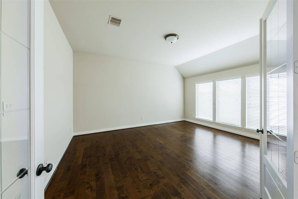This spacious game room is the perfect place for a full size pool, foosball table and other fun activities! Plenty of room for friends and family to gather for a night of games! Featuring a high angled ceiling, wood flooring and wall of windows with blinds.