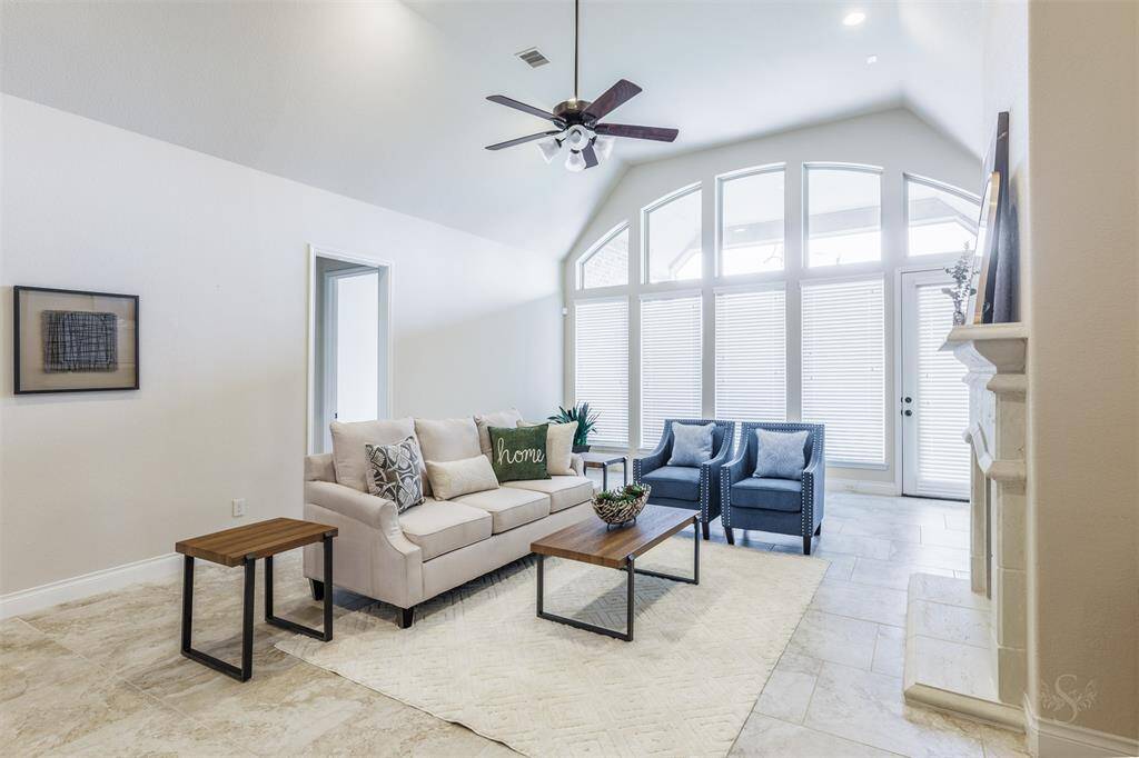 The family room boasts a wall of windows that flood the space with natural light, creating a bright and airy atmosphere. High angled ceilings and recessed lighting add to the room's sense of openness and elegance, making it the perfect place to relax and gather.