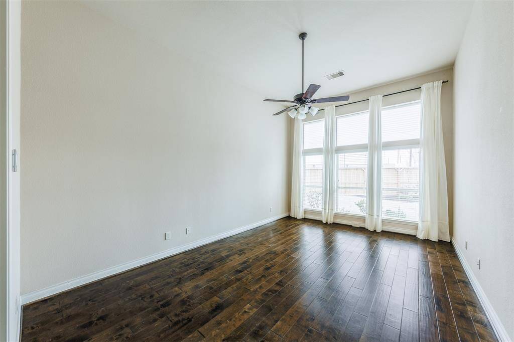 Come home and unwind in this lovely primary suite featuring a high ceiling, rich wood flooring and wall of windows bringing in natural light! Enjoy this warm and relaxing environment with plenty of space for your king size bed, dresser and a sitting area by the windows!