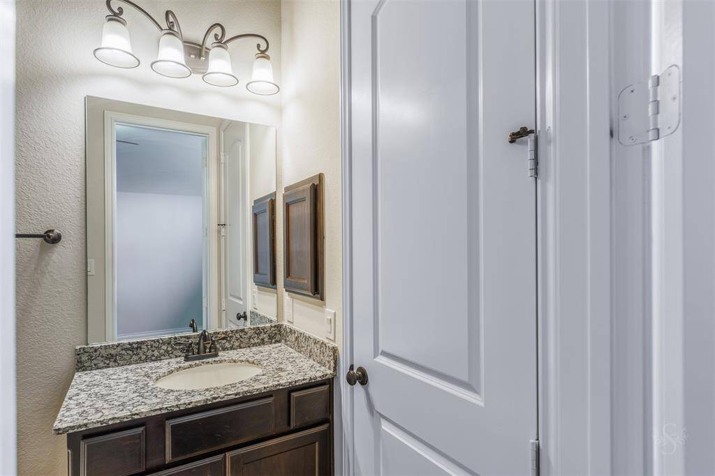 The secondary bath provides a vanity counter and accent lighting.