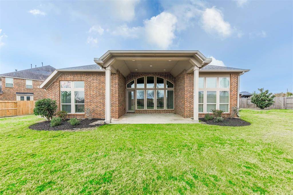 The covered back patio, with its recessed lighting, creates a cozy outdoor retreat that overlooks the expansive backyard. It's an ideal spot for family gatherings, whether you're enjoying a quiet evening or hosting a get-together.