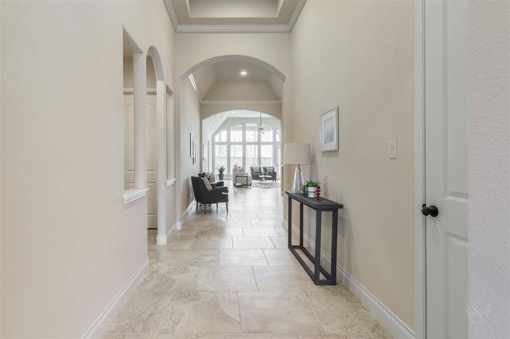 Guests will be welcomed into this charming entryway, showcasing elegant tile flooring, high tray ceilings, crown molding and the perfect space to display your favorite artwork and décor!