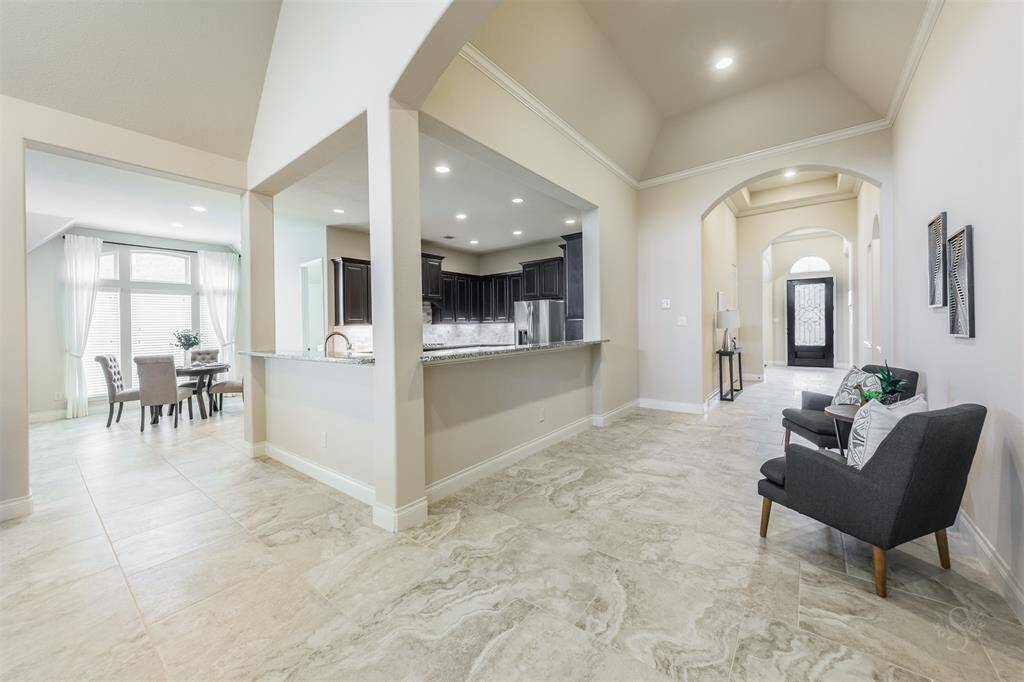 Beautiful tile flooring flows through the front entry, hallway that is spacious enough for a sitting area and to the family room.