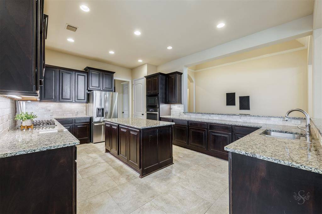 The huge chef’s kitchen is large enough for more than one cook to prepare meals. Featuring a granite island, miles of granite counters, gas cooktop, an abundance of cabinets for storage and a butler’s pantry.