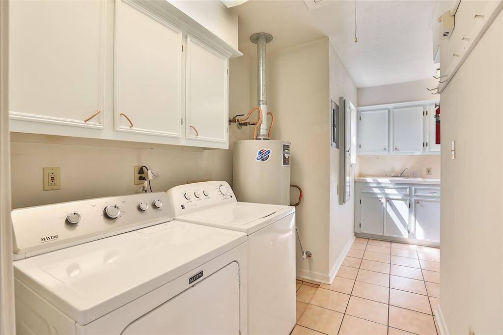 Utility room is an "L" shape!  More cabinets and storage around the corner!  Washer and dryer stay!