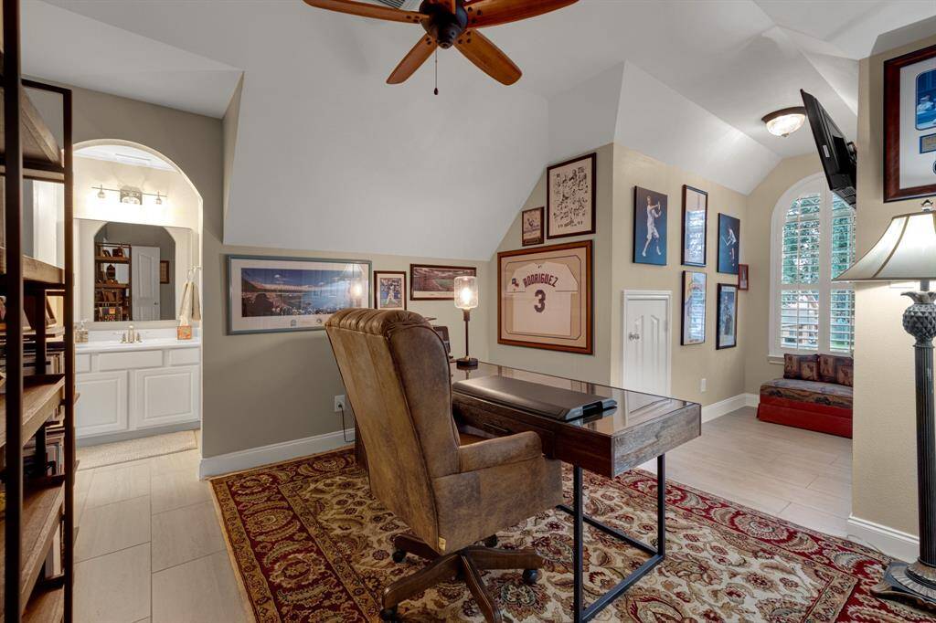 A well-lit, cozy study or living room with high ceilings, large windows.