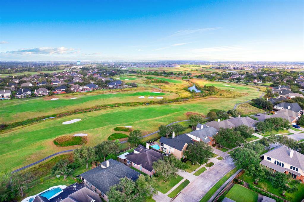 A residential area adjacent to a lush golf course, offering a serene environment with spacious backyards, manicured lawns, and a community-oriented setting with easy access to outdoor recreation.