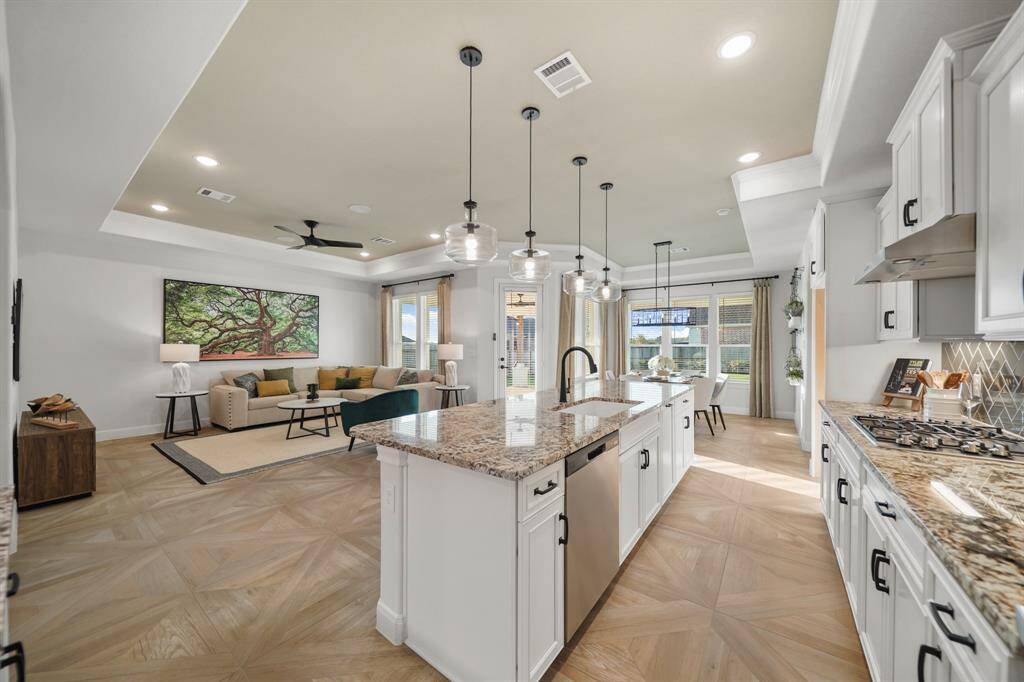 The heart of the home, this open-concept kitchen impresses with custom cabinetry, gleaming granite countertops, and a spacious oversized island perfect for gathering.