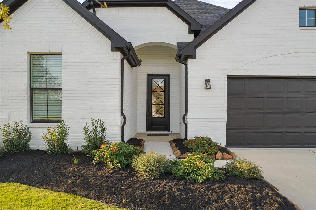 This stunning corner lot home boasts exceptional curb appeal with a beautifully manicured lawn and inviting entryway.