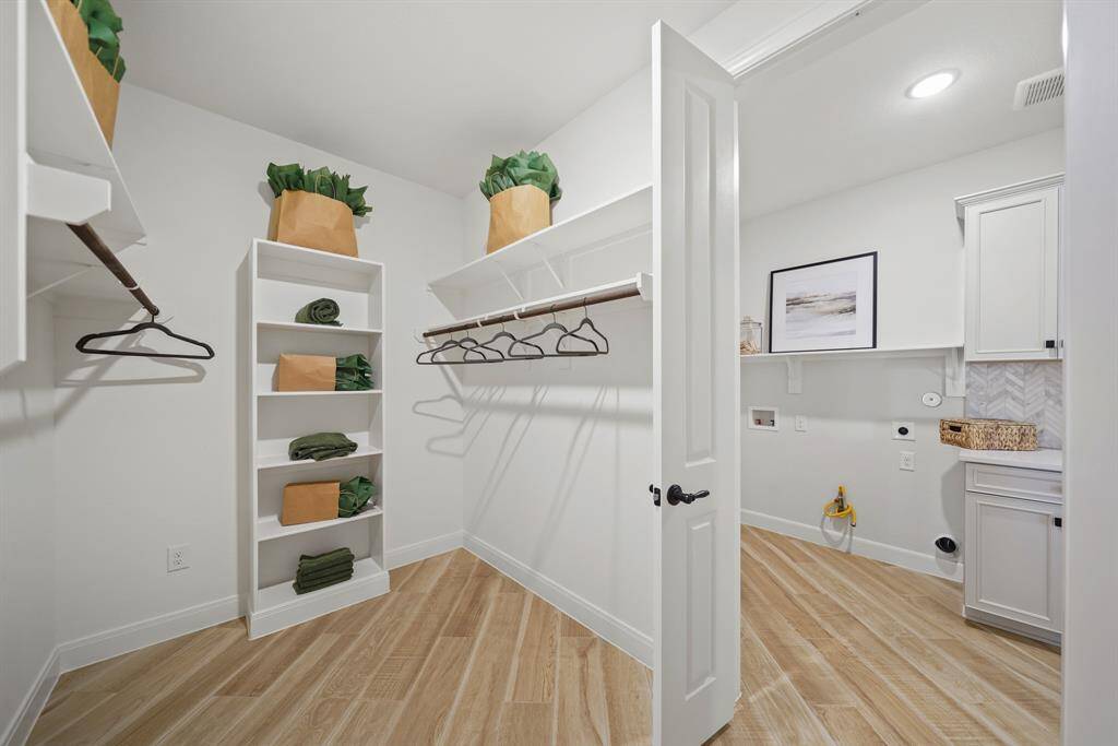 The oversized walk-in closet offers ample storage and conveniently connects to the laundry room, making organization effortless.