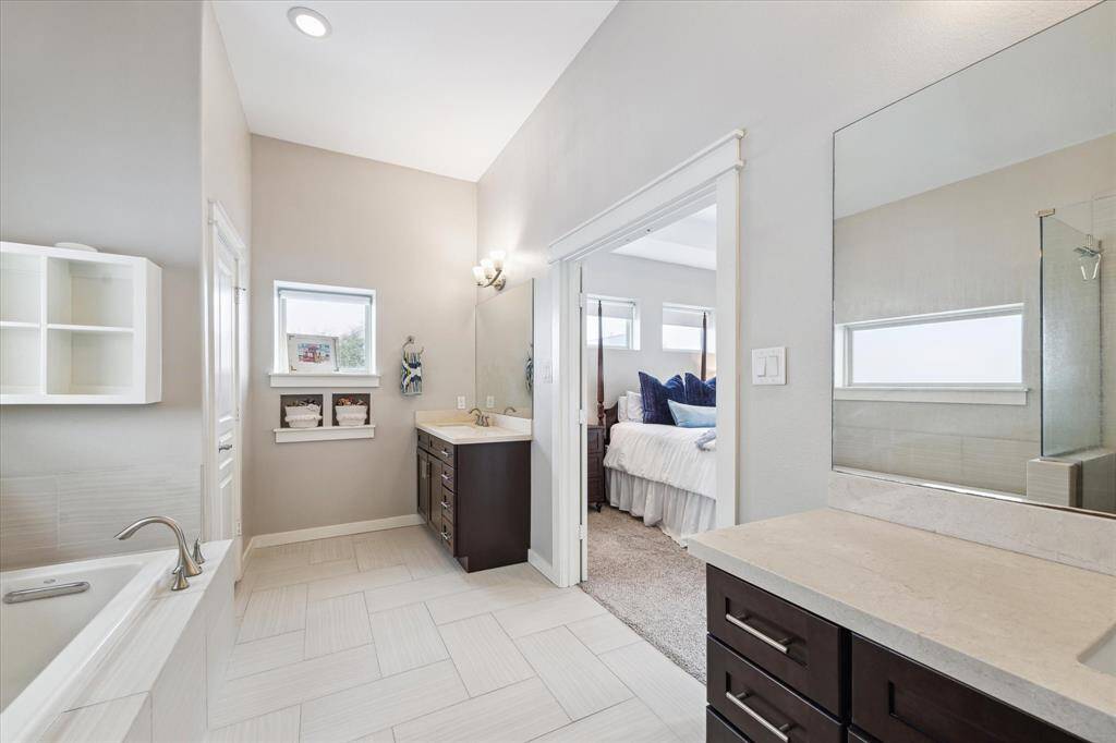 Luxurious bathroom featuring double sinks, a separate soaking tub, and a walk-in shower.