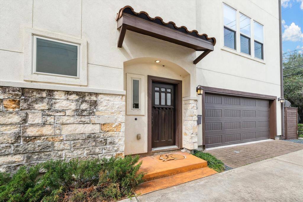 Charming corner home with a fully fenced front yard and an inviting second-floor balcony.