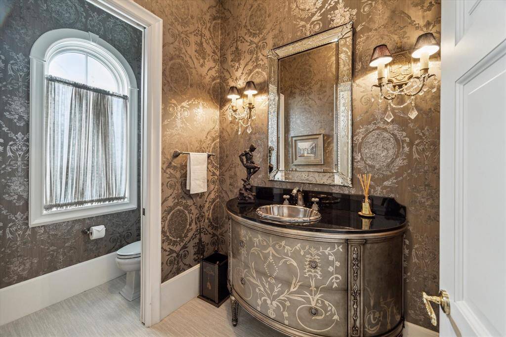 Formal powder room with luxurious wallpaper and high end selections.