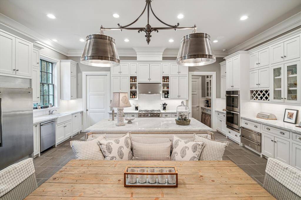 The open kitchen breakfast room is a gathering space with huge island, cozy sitting area and stainless steel appliances.