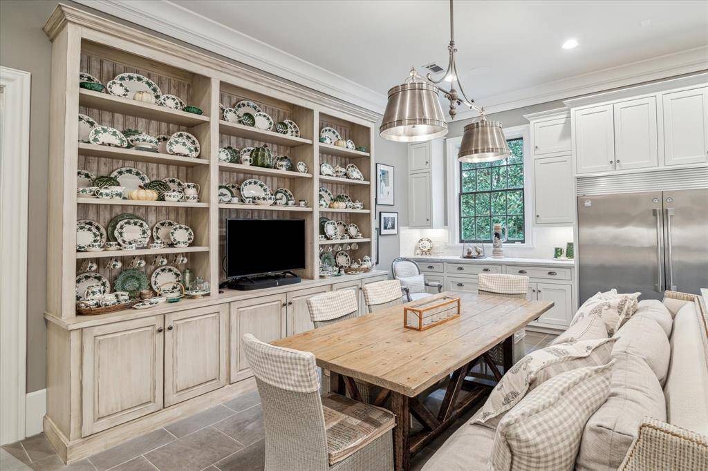 The breakfast room features a beautiful built-in display cabinet with Tv space and stylish metal lighting.