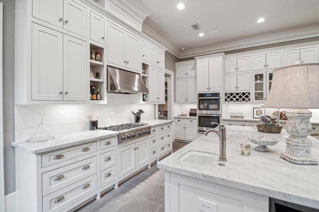 The kitchen includes a vegetable sink in addition to a large porcelain sink, two ovens, two warming drawers and large refrigerator and freezer.