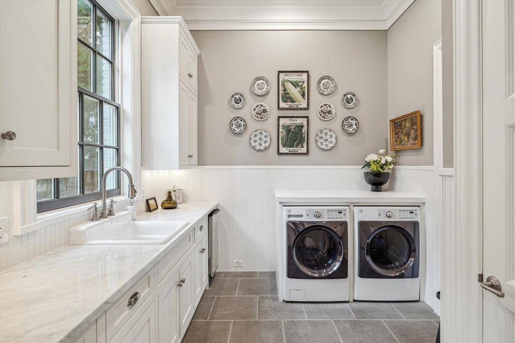 Great laundry room with large sink, window with view of the side yard and half bath.