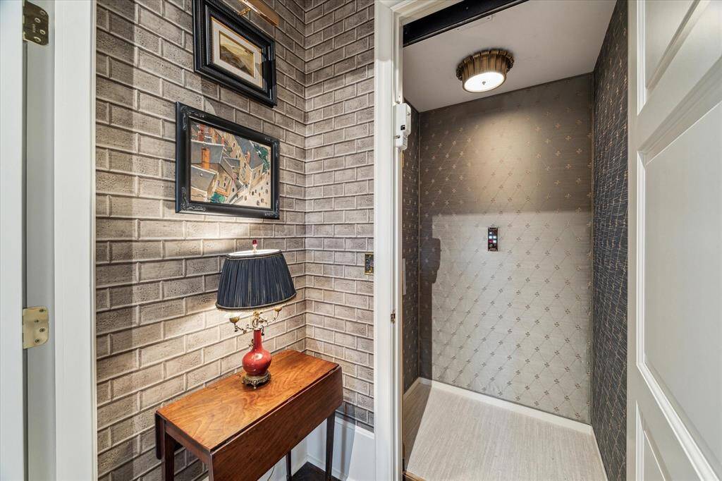 The elevator features fabric walls and charming light fixture.