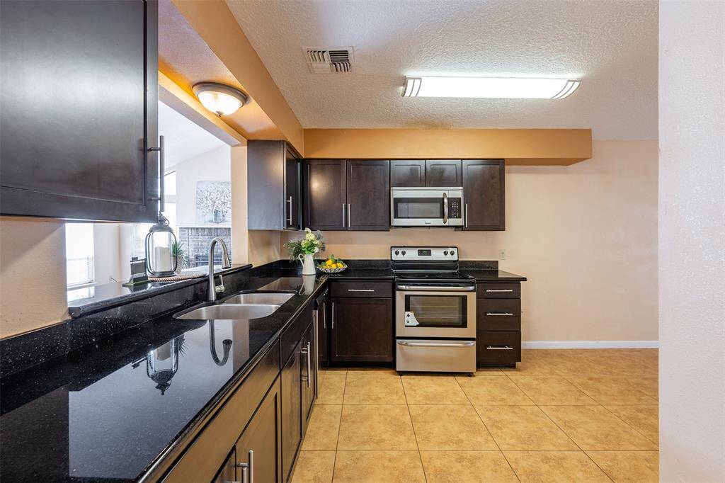 The upgraded kitchen features granite countertops and stainless steel appliances, combining style and functionality for a modern cooking experience.