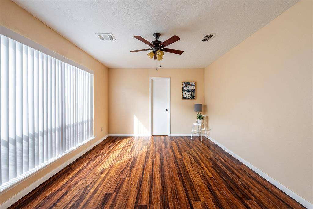 The primary bedroom is nestled in a private corner of the home, featuring a large window that offers a peaceful view of the side yard, bringing in plenty of natural light.