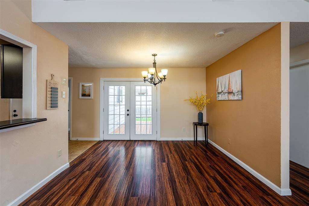 A beautiful formal dining area featuring two-tone paint colors. The French doors open to wood deck patio, providing the perfect setting for seamless indoor-outdoor entertaining.