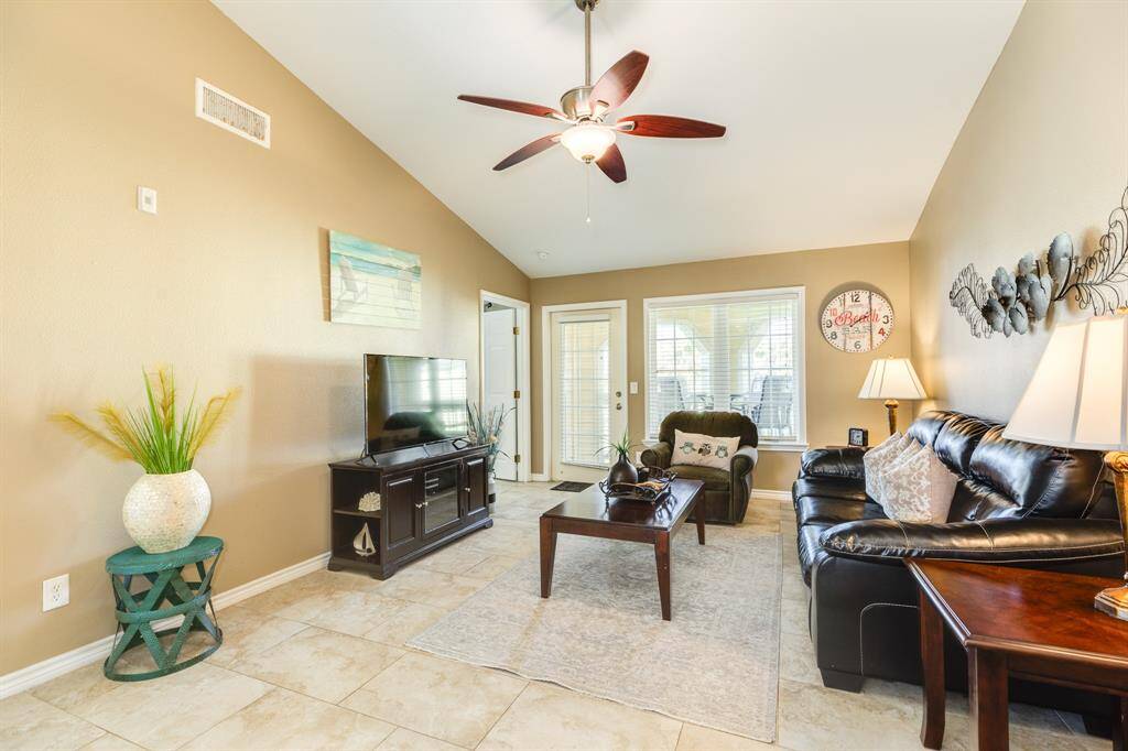 Spacious living room with tile floors and high ceiling.