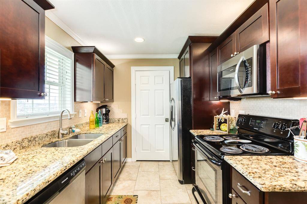 Kitchen is laid out for ease in use and efficient space use, Plenty of cabinet space both above and below the countertops. Door in view leads to the utility room.