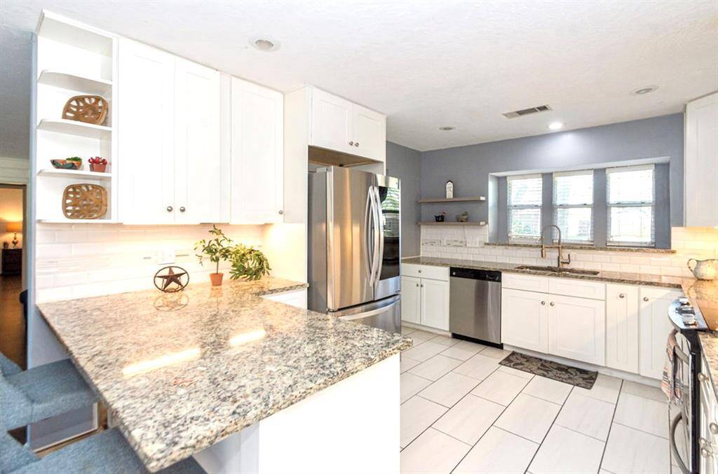 The custom tile flooring compliments the white kitchen! The Refrigerator may convey with a full price offer!