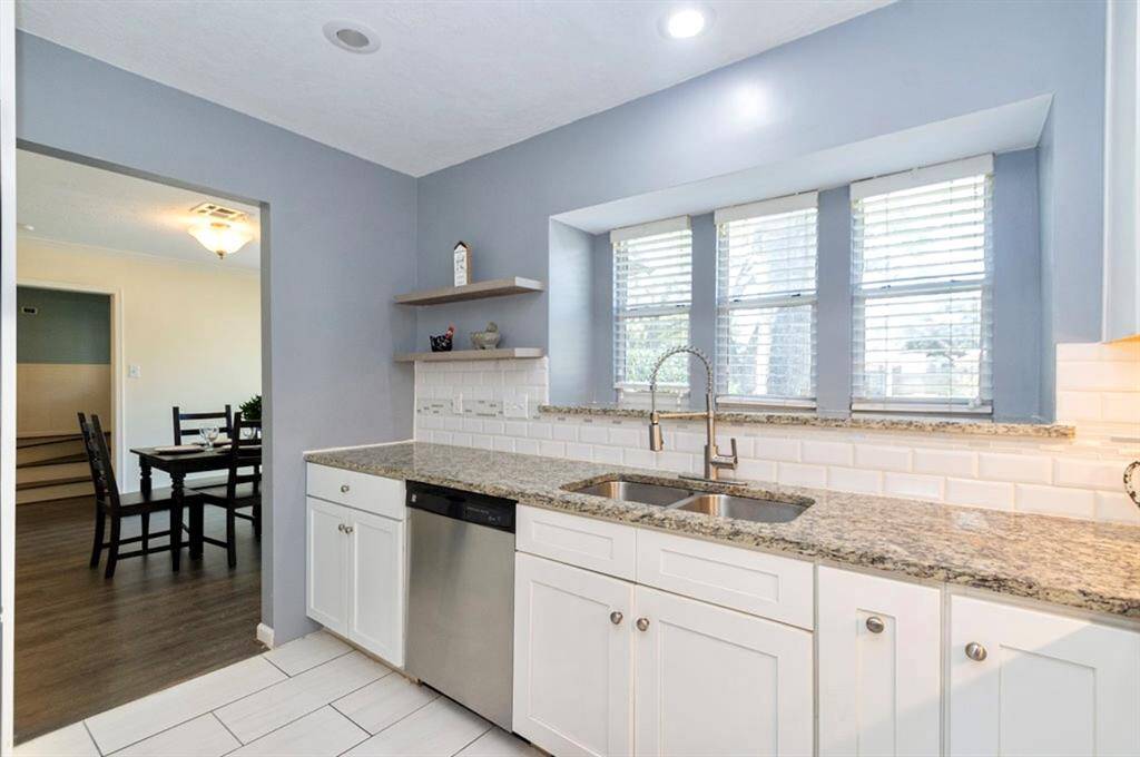 Custom shelving and a window ledge provide lots of space for displaying your kitchen collectibles! Updated SS appliances make meal prep and clean up a breeze! Recessed lighting fills the space!