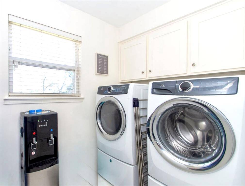 The laundry room has cabinetry, houses the hot water heater and has plenty of storage space!Photo enhanced.