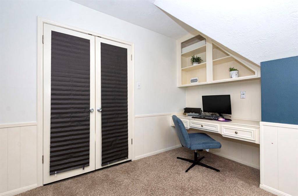 This bedroom (Bedroom 3) has a dedicated desk with built-ins! The French Doors with shades provide privacy! It also has a walk-in closet!