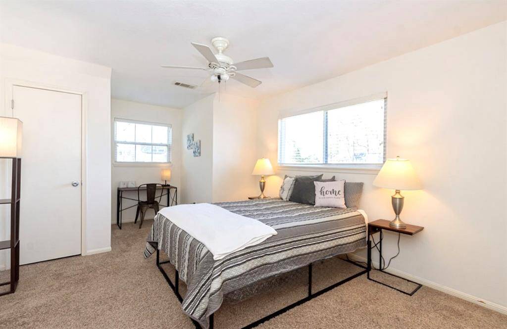 Bedroom 4 is at the end of the hallway and has an updated ceiling fan with light, wall paint, Low E Double Pane Windows with two closets and a Dormer space for a desk or reading nook!Photo enhanced.