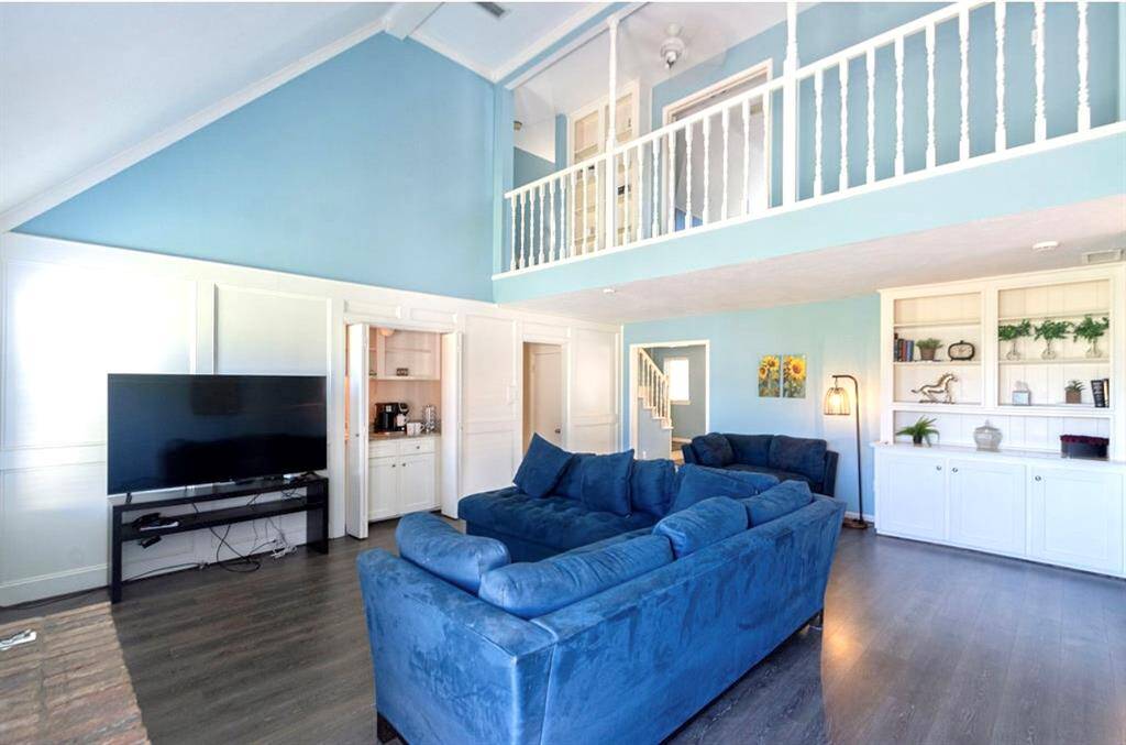 The vaulted ceiling highlights the upstairs bannister and hallway! Beautiful updated blue walls and natural light makes it so  for hanging out or entertaining guests!