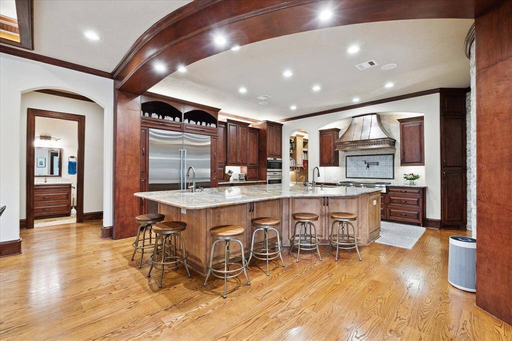 The large island kitchen boasts SubZero and Wolf appliances, a handcrafted Copper vent hood , an instant hot water dispenser, hands-free toe kick switch for both garbage disposals, custom cabinetry throughout the kitchen and a large walk-in pantry