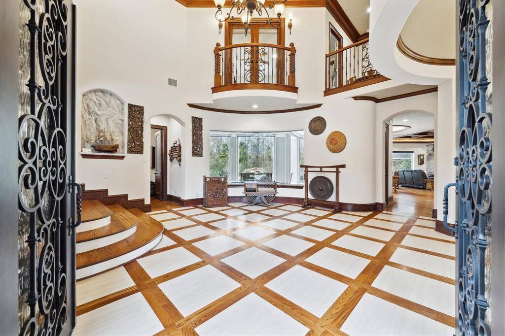 As you enter this upscale home, you are graciously welcomed by paterned wood and tile flooring as well as a view of the pristinely maintained yard.