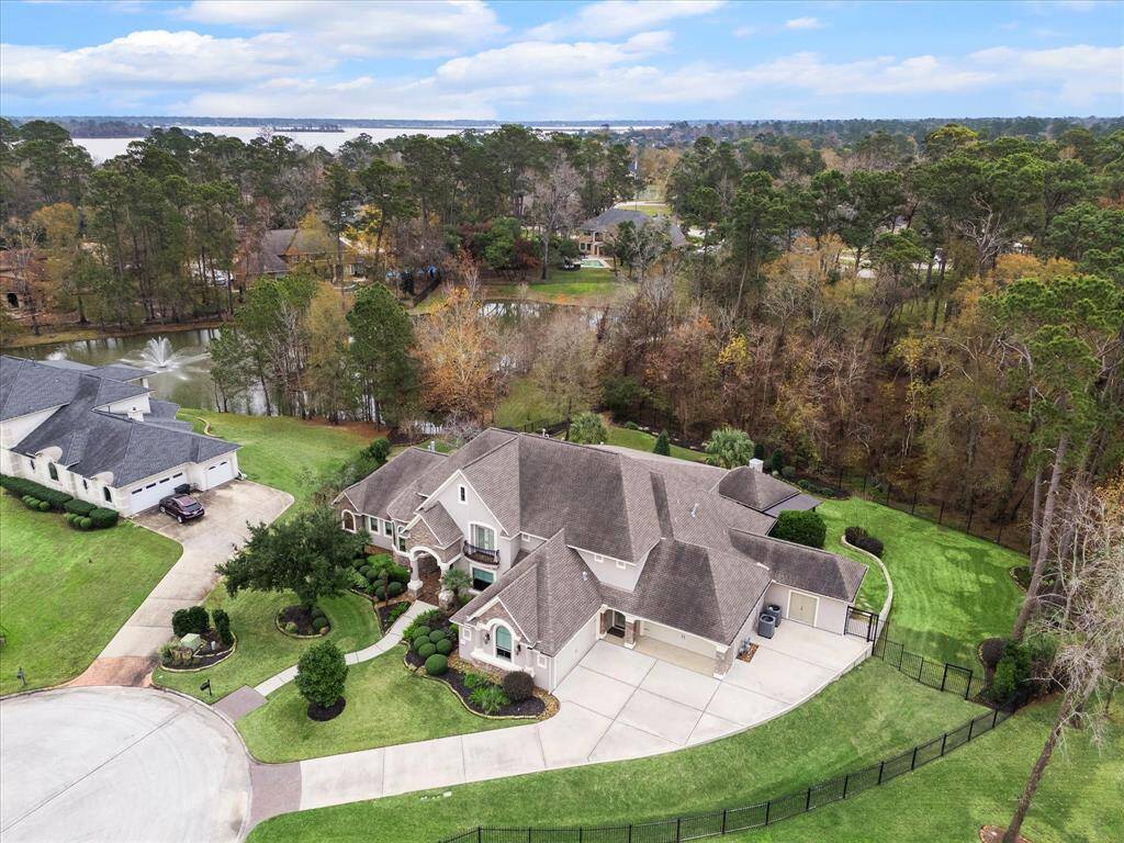 This stunning home is nestled in a serene, wooded area with a nearby pond and fountain, offering a peaceful retreat. It features a spacious driveway, well-maintained landscaping, and ample outdoor space, ideal for relaxation and entertainment.