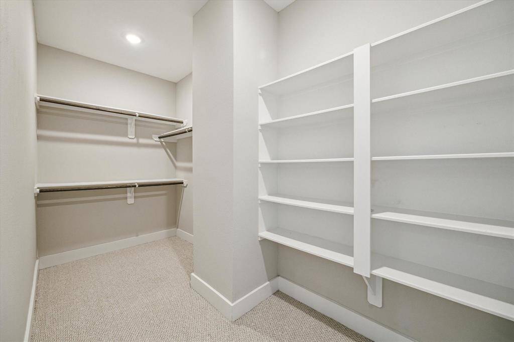 Primary closet sports plenty of shelving as well as hanging space. There is tons of space which can be configured in multiple ways.