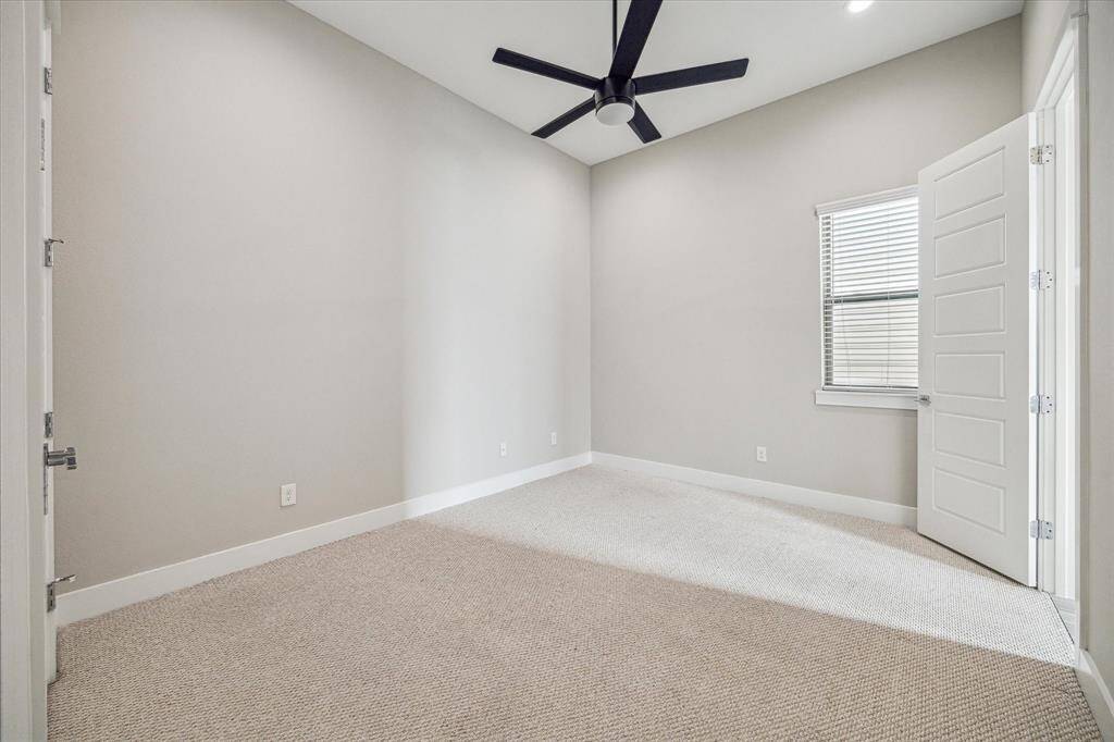 Roomy secondary bedroom with ceiling fan. Door opens to shared bathroom.