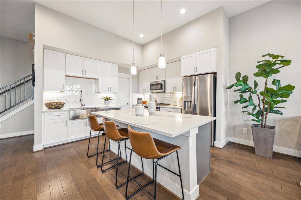 Pull up to the breakfast bar, punctuated with designer pendent lighting.