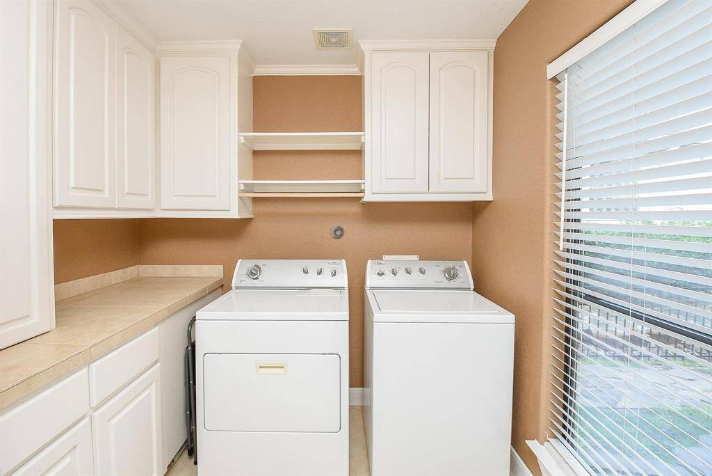 large utility room with lots of cabinets for storage and extra fridge