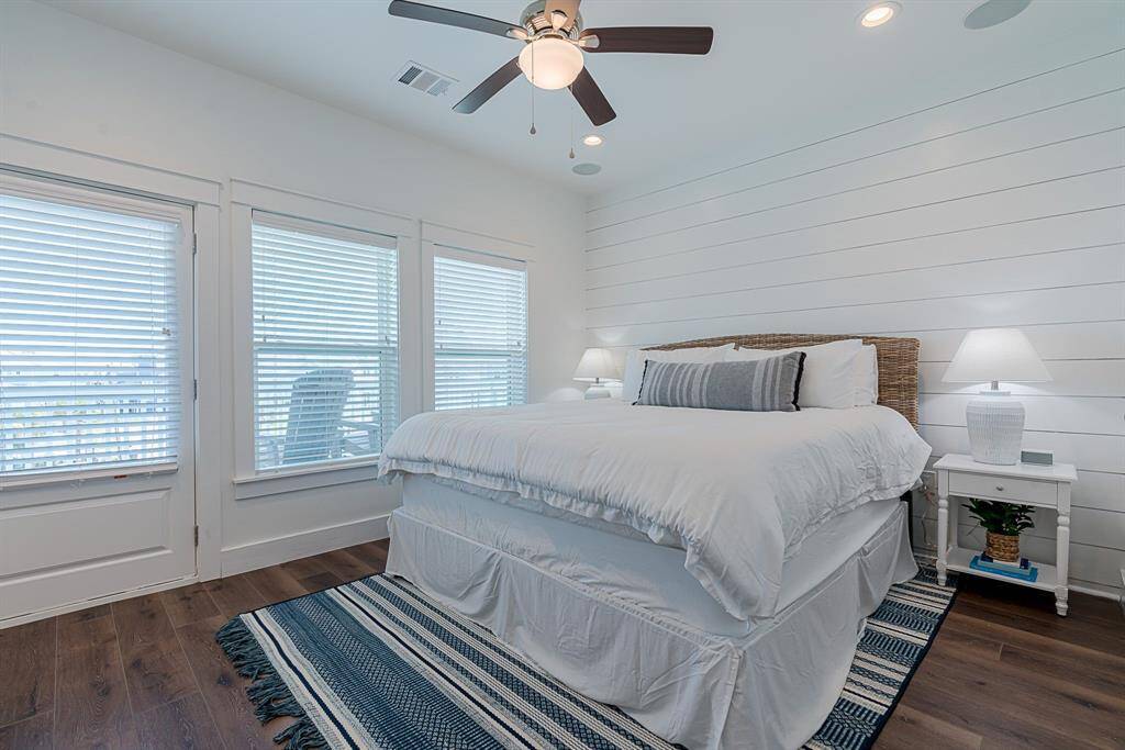 Primary bedroom accented with a shiplap wall, outdoor deck access