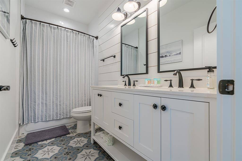 Second full bath, double sink vanity, framed mirrors and designer tile flooring