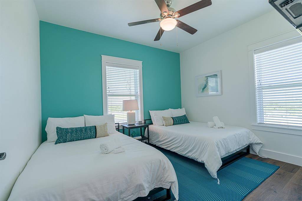 Third bedroom with ceiling fan and cased windows