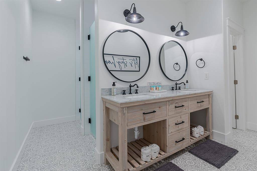 Third full bath, double sinks, framed mirrors and two, stand alone showers