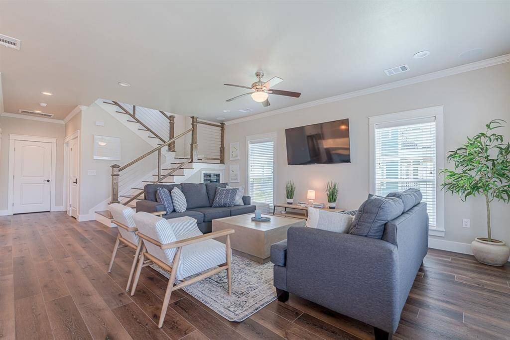 Spacious living room with ceiling fan and cased windows!