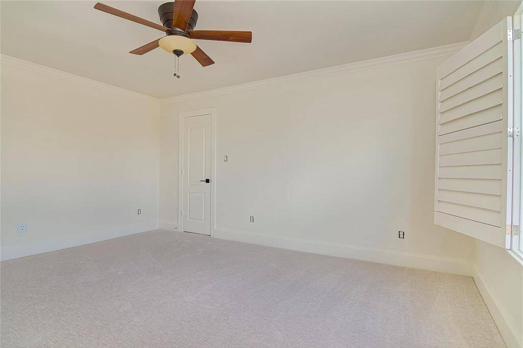 Carpeted bedroom with plantation shutters.