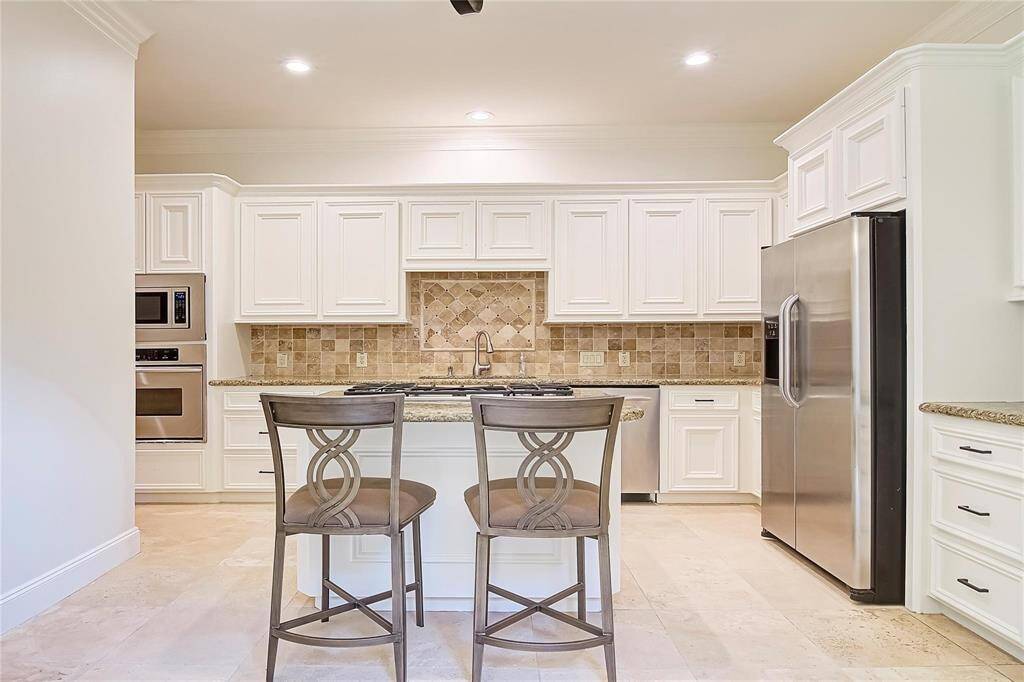 Bright kitchen with granite countertops and stainless steel appliances